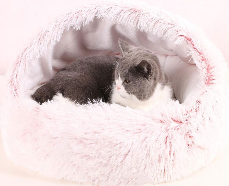 Pink fluffy cat cave bed with kitten resting inside